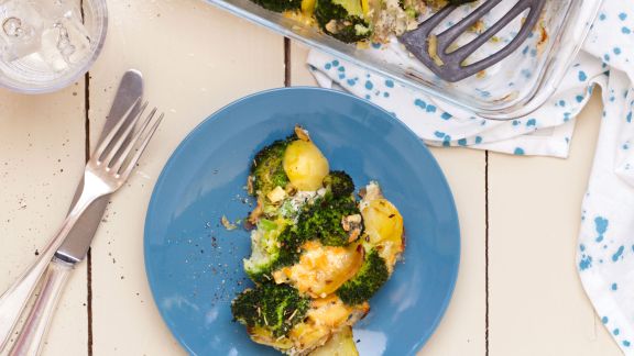 Auflauf mit Brokkoli und Kartoffeln auf blauem Teller